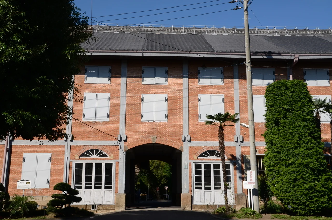 Front of the East Cocoon Warehouse, with red brick panels divided by timber framing and an arched central passage.