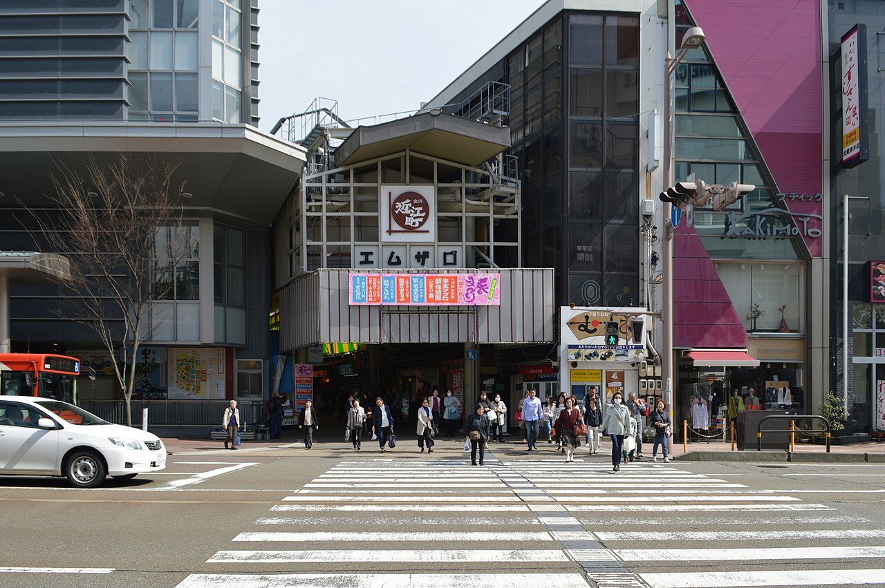 近江町市場の入口へ続く横断歩道と、通りを歩く人々。